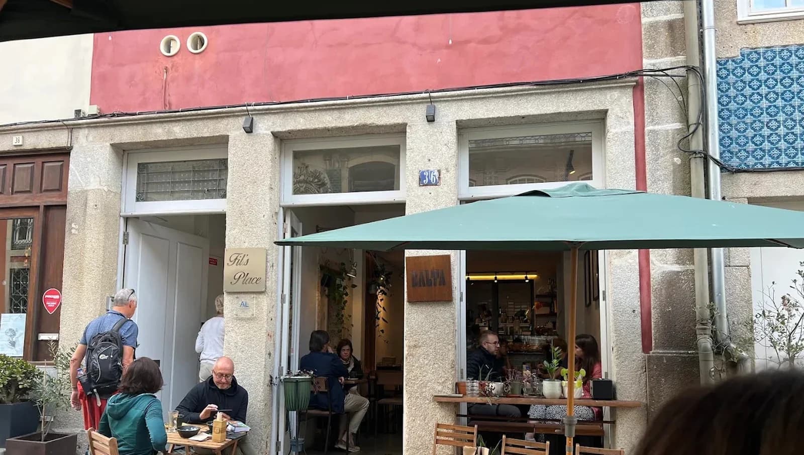 The Balta Brunch façade from the street, with the terrace, the awning and people at the tables